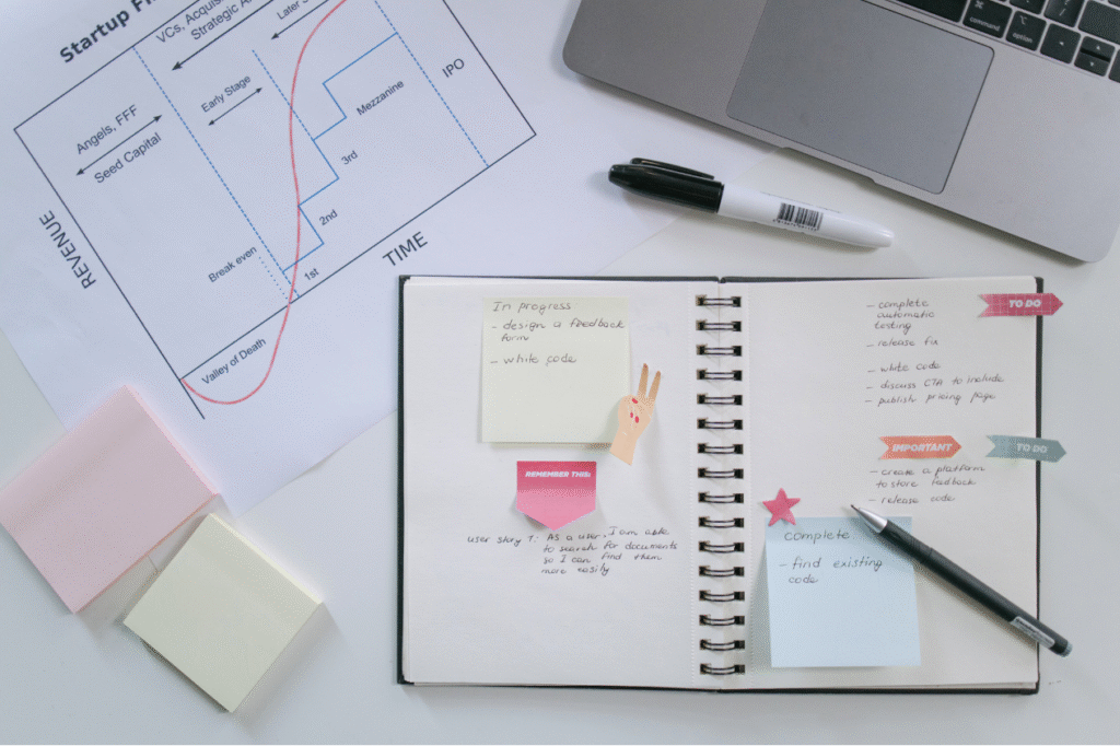 Startup business planning notebook with financial growth chart and laptop
